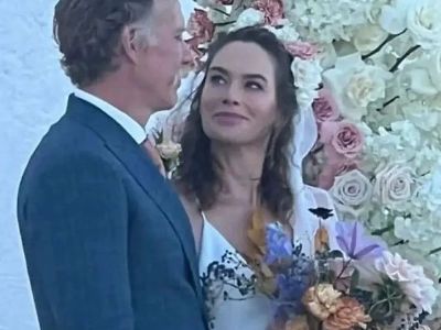 Lena Headey and Marc Menchaca are in their wedding clothes looking at each other.